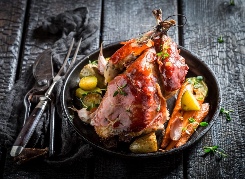 Fresh pheasant with bacon and spices on dark background